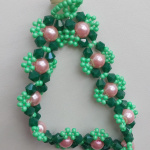 Зеленый браслет с биконусами и розовыми бусинами